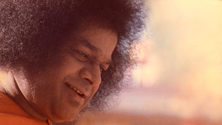 Sai Baba smiling gently with compassionate expression