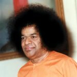 shri sathya sai baba in orange attire with afro photo