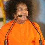 Spiritual leader speaking at podium with microphones photo