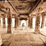 Ancient stone temple hall with devotee image