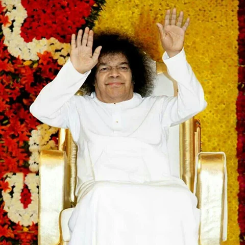 Shri Sathya Sai Baba Person seated, hands raised in greeting.