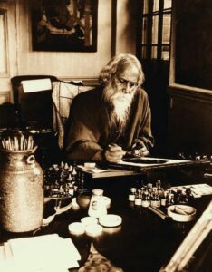 Rabindranath Tagore writing at desk image