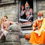 Three Hindu sadhus seated outside temple image