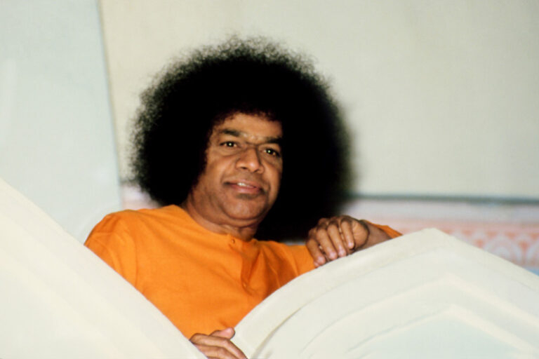 Sathya Sai Baba leaning over balcony picture.