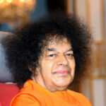 Sathya Sai Baba in red chair picture.
