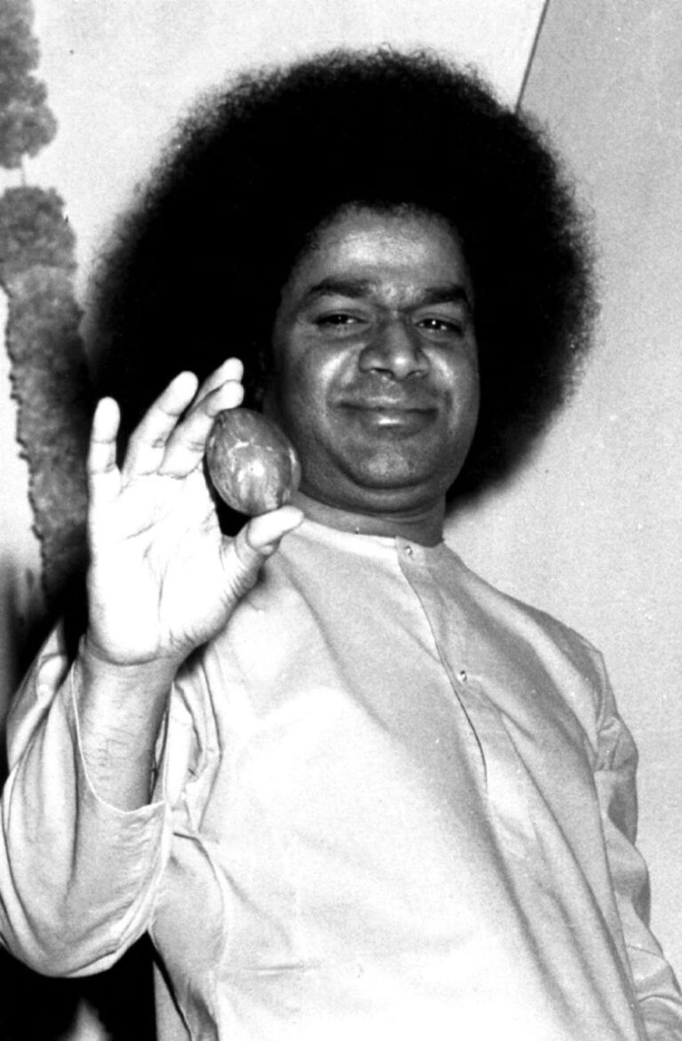 Sathya Sai Baba holding a small object