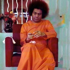 Sathya Sai Baba looking at his hands.