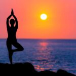 Person practicing yoga at sunrise image
