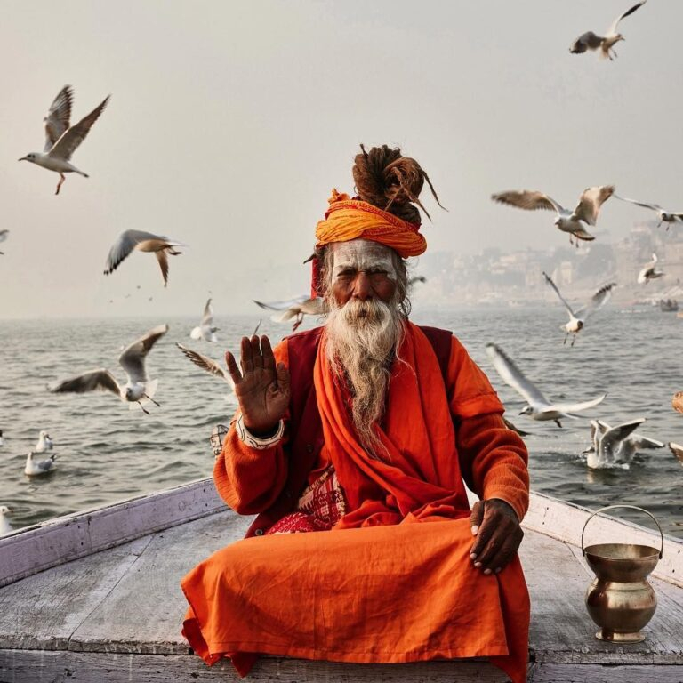 Sadhu blessing on boat with seagulls.