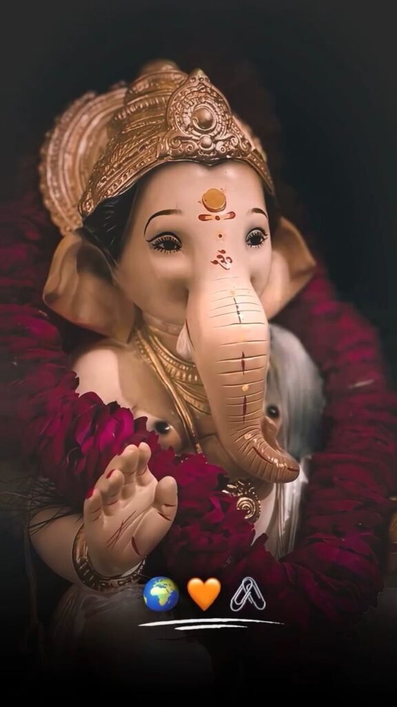 Close-up of Lord Ganesha idol with crown and flower garland giving blessing. image