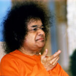 Sathya Sai Baba raising his right hand.