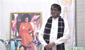 Spiritual speaker before Bhagwan Shri Sathya Sai portrait