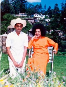 Shri Sathya Sai Baba with young devotee outdoors