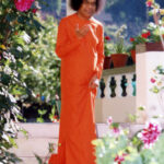 Sathya Sai Baba walking down outdoor stairs.