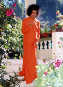Sathya Sai Baba walking down outdoor stairs.