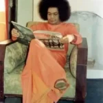 Sri Sathya Sai Baba reading spiritual magazine peacefully