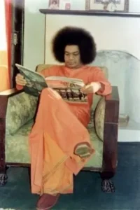 Sri Sathya Sai Baba reading spiritual magazine peacefully