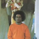 Sri Sathya Sai Baba before Lord Krishna statue
