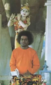 Sri Sathya Sai Baba before Lord Krishna statue
