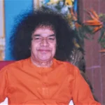 Shri Sathya Sai Baba smiling while seated picture