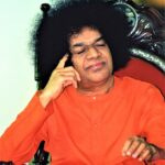 Shri Sathya Sai Baba seated thoughtfully picture