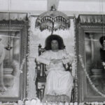 Sathya Sai Baba seated between two portraits.