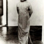 Young Sathya Sai Baba standing looking forward.