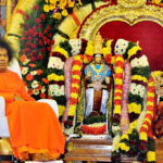 Shri Sathya Sai Baba beside Shiva Parvati Kalyanam idols
