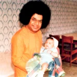 Bhagwan Shri Sathya Sai Baba holding baby picture