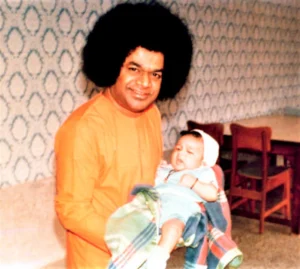 Bhagwan Shri Sathya Sai Baba holding baby picture