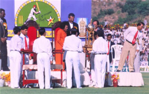Sathya Sai Baba presenting a cricket trophy.