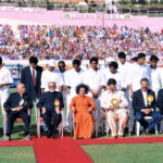 Sathya Sai Baba sitting with cricket players.