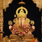 Golden Lord Ganesha idol in temple shrine.