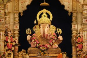 Golden Lord Ganesha idol in temple shrine.
