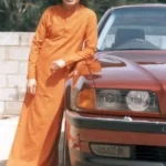 Sri Sathya Sai Baba standing beside car with smile