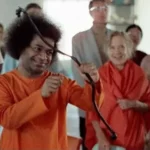 Bhagawan Sri Sathya Sai Baba demonstrating archery with devotees