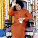 Sri Sathya Sai Baba smiling while blessing devotees