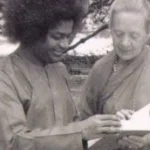 Sri Sathya Sai Baba reading with devoted disciple
