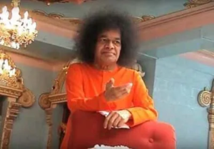 Sri Sathya Sai Baba giving divine blessings seated