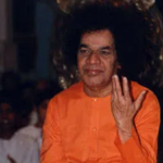 Sri Sathya Sai Baba blessing devotees with raised hand