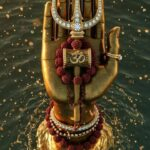 Golden hand holding Trishul and Om.