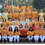 Group of devotees gathered with portraits of Sri Swami Sivananda during a spiritual retreat
