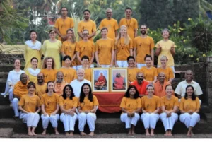 Group of devotees gathered with portraits of Sri Swami Sivananda during a spiritual retreat