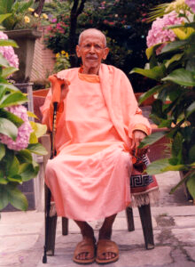 Elderly Hindu monk seated peacefully in a garden
