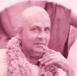 Swami Sivananda wearing flower garland gazing thoughtfully with serene expression always