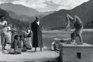 Yoga practitioner demonstrating advanced pose before guru and attentive disciples together