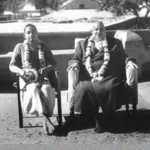 Swami Venkateshananda and Swami Sivananda sitting outdoors.