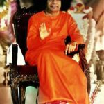 Shri Sathya Sai Baba blessing seated devotees