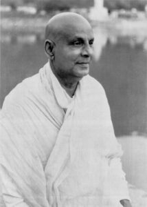 Swami Sivananda gazing peacefully beside sacred river