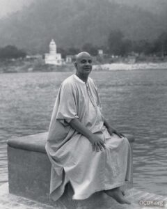 Swami Sivananda meditating peacefully beside sacred river